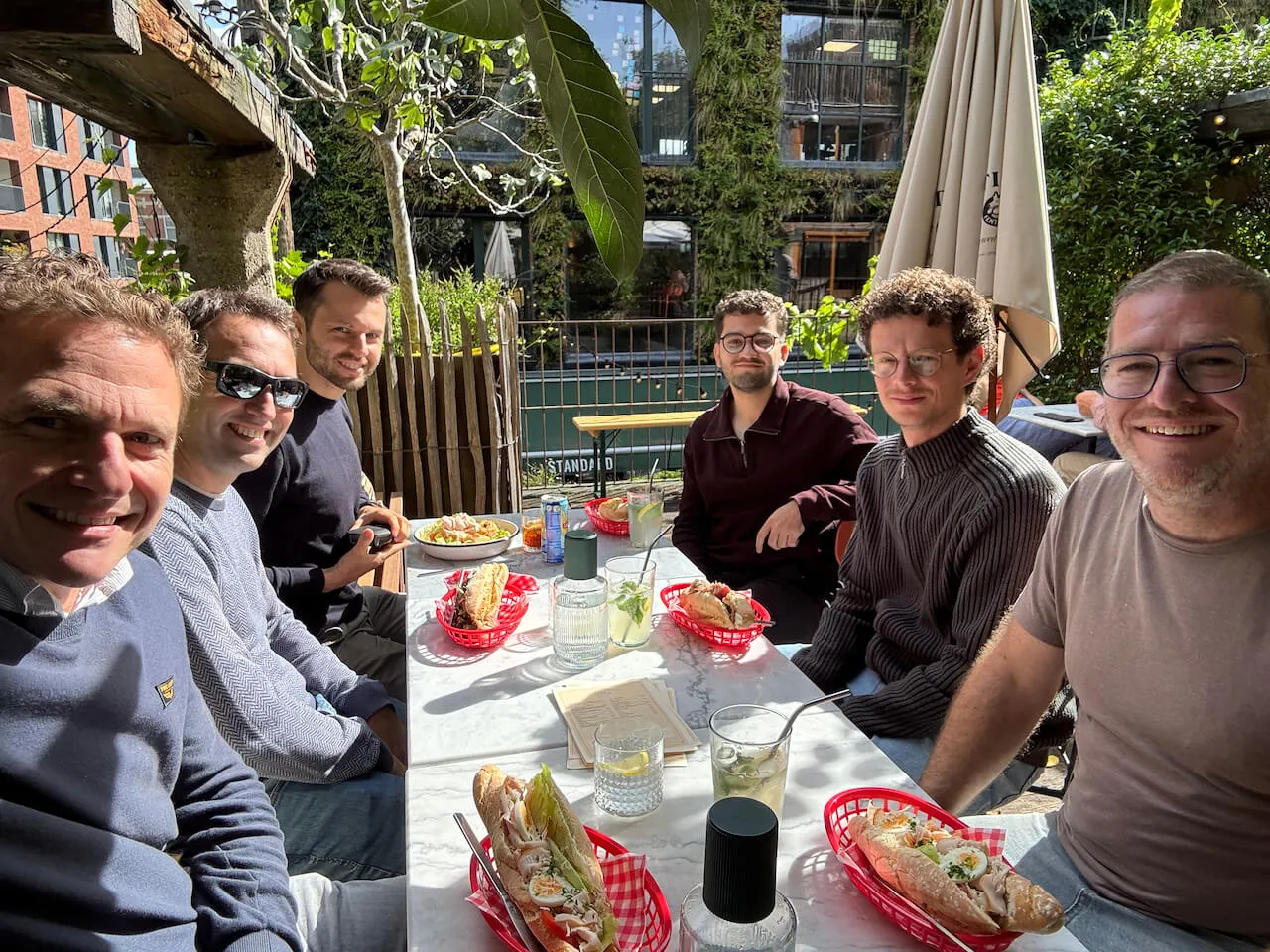 The Sevendays team together at a table during lunch on a sunny terrace.