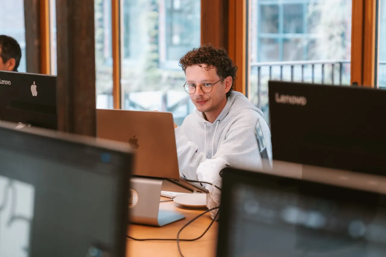 Een collega van Sevendays aan het werk achter zijn laptop op kantoor