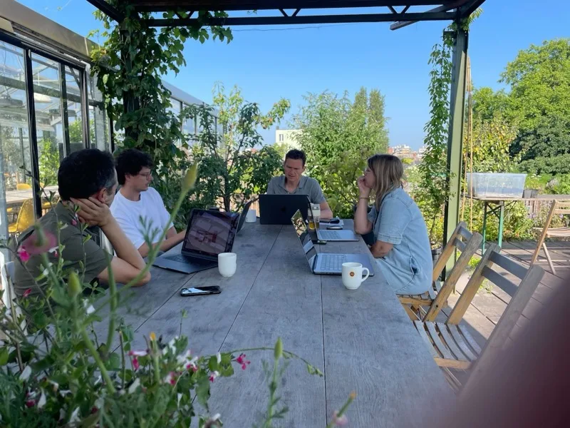 The Sevendays team brainstorming around a table on the rooftop terrace