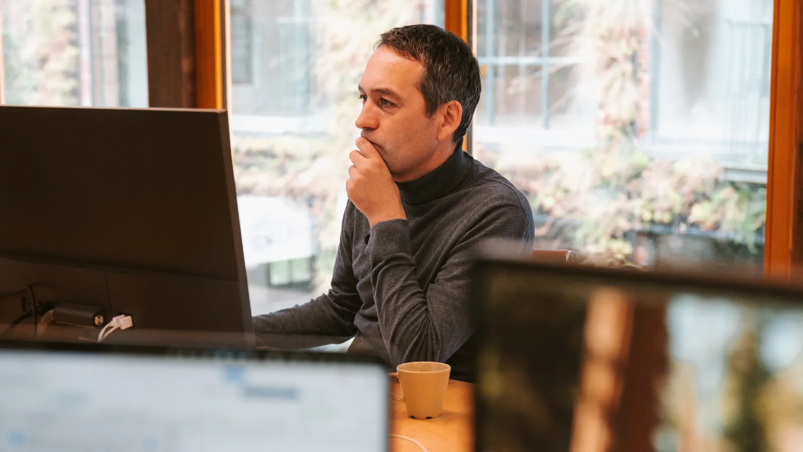 A team member working, focused, at a laptop by the window